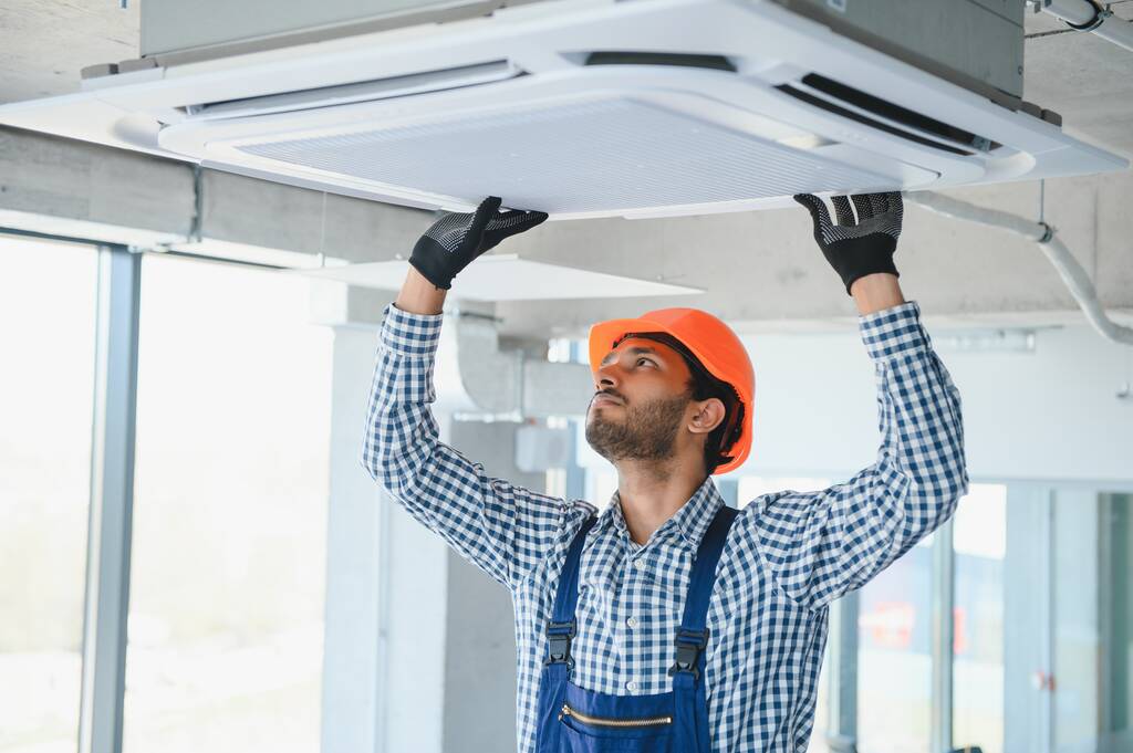 specialist reinigt en reparaties van de muur airconditioner. - Foto, afbeelding