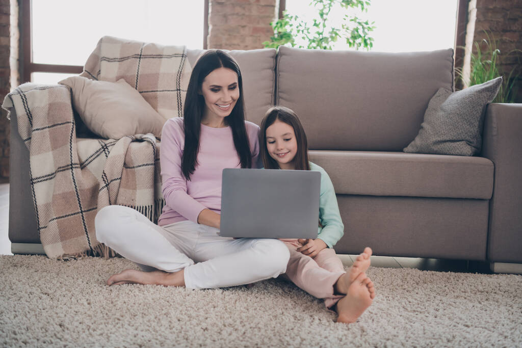 Photo of cheerful sweet mother daughter wear casual outfits watching videos modern device indoors house room. - Photo, Image