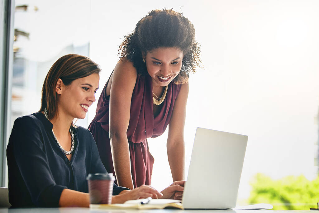 Nowoczesna technologia zapewnia maksymalny przepływ pracy. dwie bizneswoman pracujące razem na laptopie w biurze - Zdjęcie, obraz
