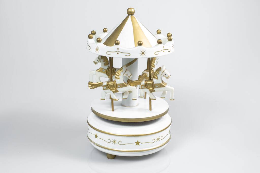 Biała karuzela Musical Box Zabawka ze złotymi końmi na białym tle - Zdjęcie, obraz