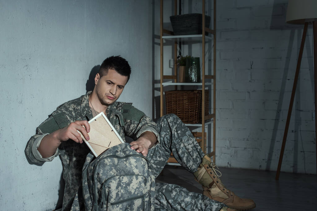 vétéran militaire avec détresse émotionnelle prendre un cadre photo du sac à dos la nuit  - Photo, image