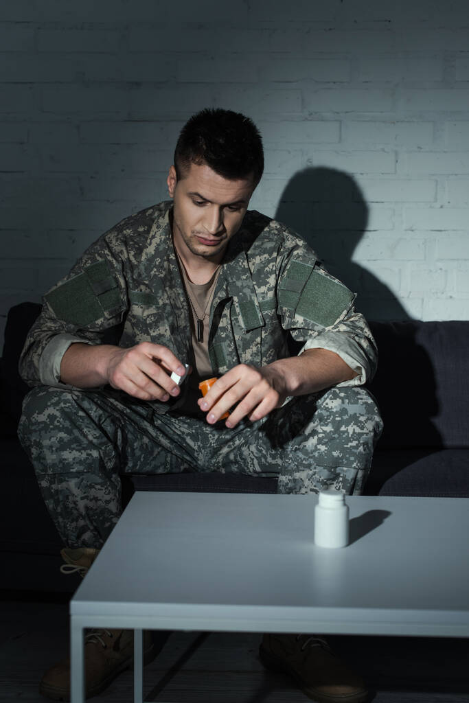 Военный ветеран с психическими проблемами, хранящий таблетки от ПТСД дома ночью  - Фото, изображение