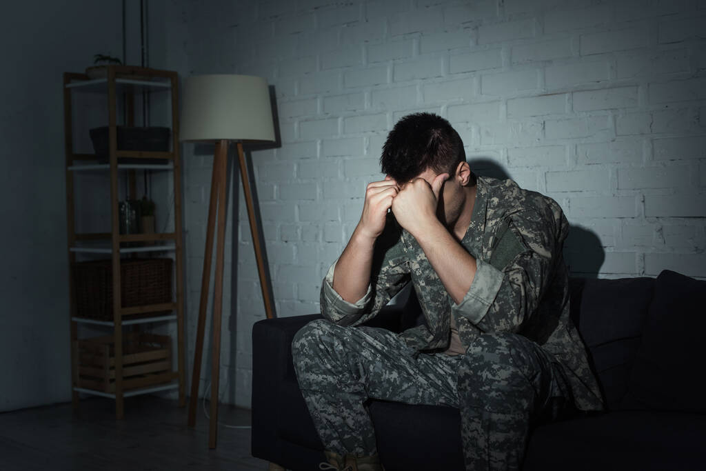 Veterano militar en uniforme sufriendo de angustia emocional en casa por la noche  - Foto, imagen