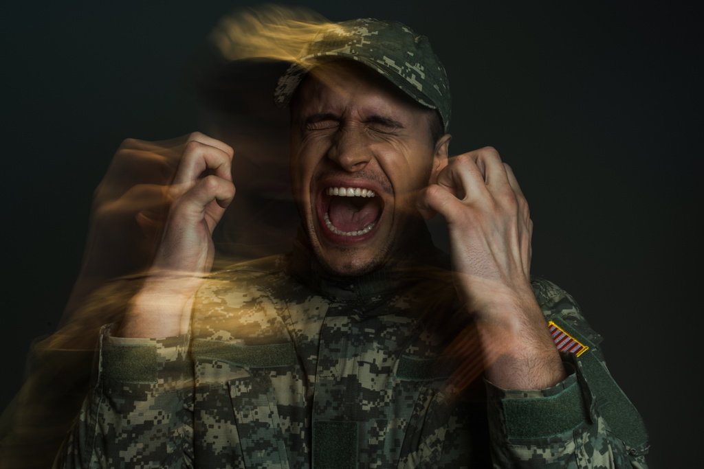 Double exposure of anxious soldier in camouflage uniform screaming while suffering from ptsd isolated on dark grey  - Photo, Image