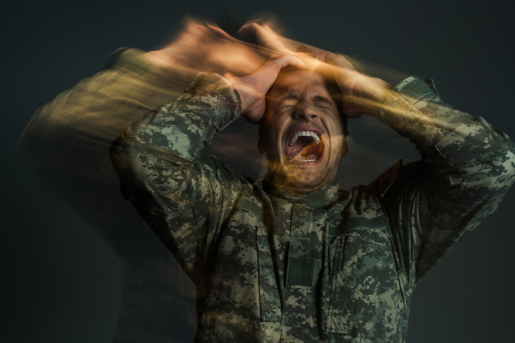 lange blootstelling van soldaat in uniform schreeuwen terwijl hij lijdt aan dissociatiestoornis geïsoleerd op donkergrijs  - Foto, afbeelding