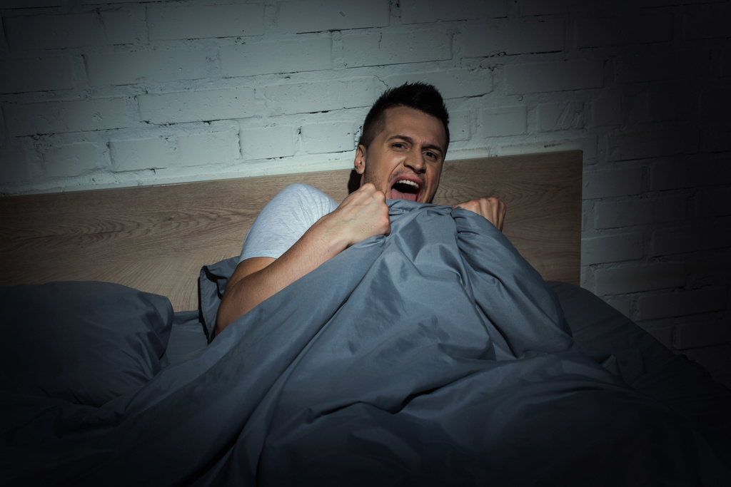 rémült férfi pánikrohamok sikoltozik, miközben rémálom éjjel  - Fotó, kép