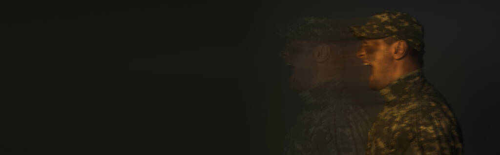 lunga esposizione di soldato che soffre di disturbo da stress post traumatico e urla isolate su nero, banner  - Foto, immagini