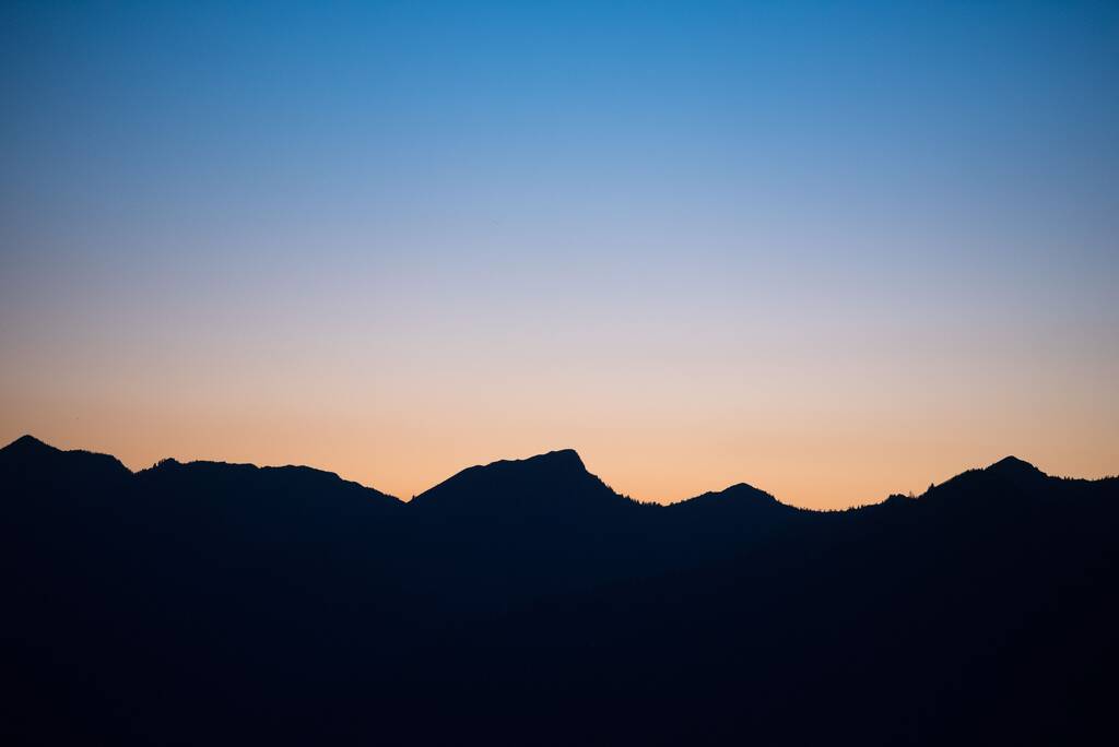 A hegyi düh sziluettje naplementével a háttérben Vorarlbergben, Ausztriában - Fotó, kép