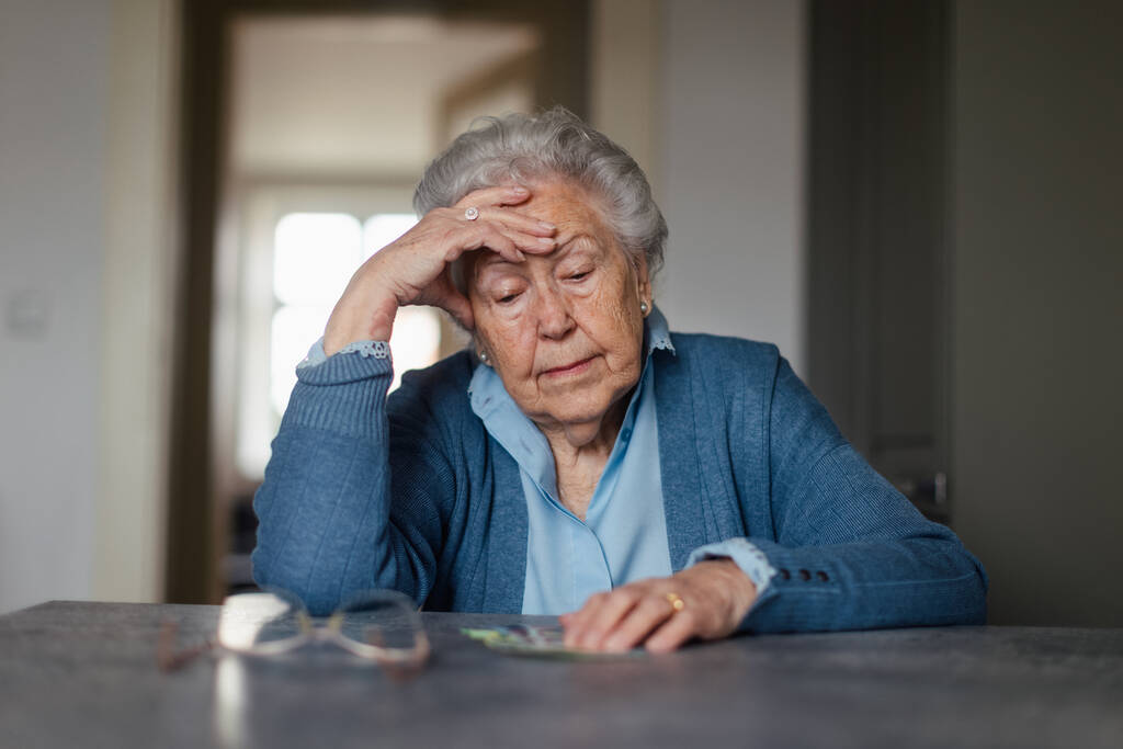 Infelice donna inferiore contando la sua pensione a casa. - Foto, immagini