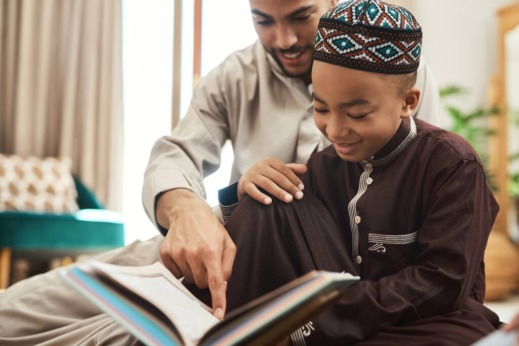 Um leitor vive mil vidas antes de morrer. um jovem muçulmano e seu filho lendo no salão em casa - Foto, Imagem