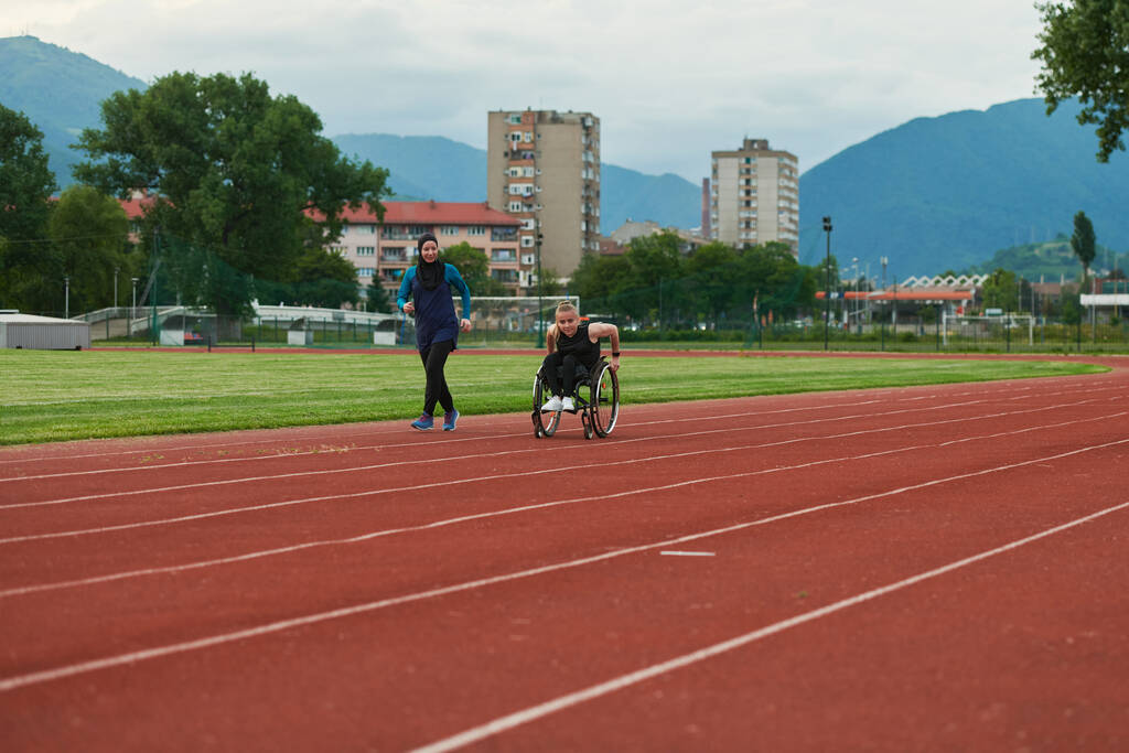 Een moslimvrouw in een boerka die samen met een vrouw in een rolstoel op de marathonbaan rent en zich voorbereidt op toekomstige wedstrijden - Foto, afbeelding
