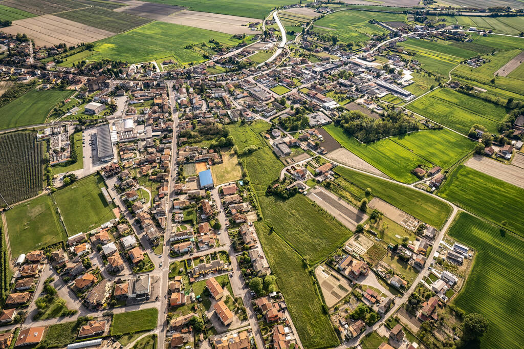 Perspective aérienne captivante d'un village pittoresque niché au milieu des terres agricoles luxuriantes et verdoyantes de la vallée du Pô en Italie - Photo, image