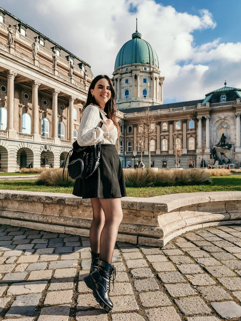 Una verticale di una giovane donna attraente in piedi nel cortile del palazzo reale di Buda a Budapest - Foto, immagini