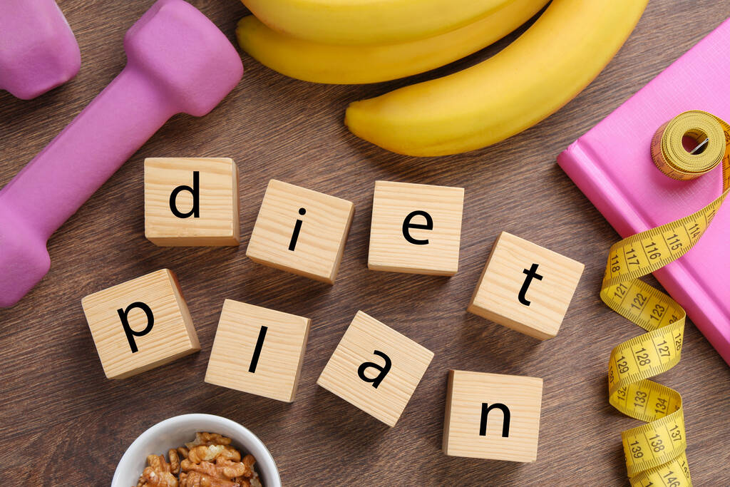 Phrase Diet Plan made of cubes, fitness items and products on wooden table, flat lay. Weight loss concept - Photo, Image