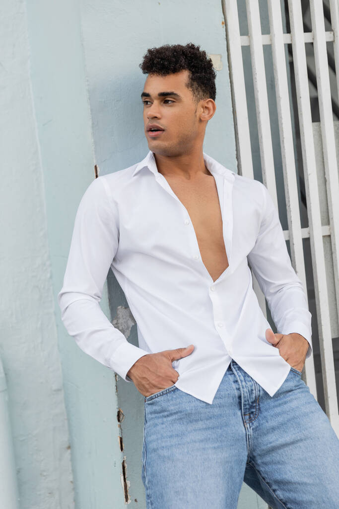 Beau cubain homme en chemise blanche et jeans bleus posant dans la rue à Miami, plage du sud - Photo, image
