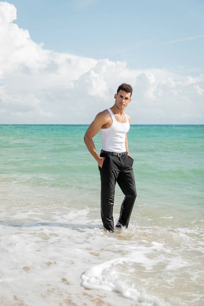 muscoloso giovane cubano in piedi in acqua oceano a Miami South Beach, mani in tasca - Foto, immagini
