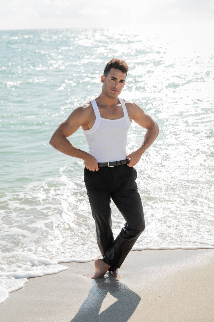 hombre cubano guapo y musculoso parado en el agua del océano en Miami South Beach, Florida - Foto, Imagen