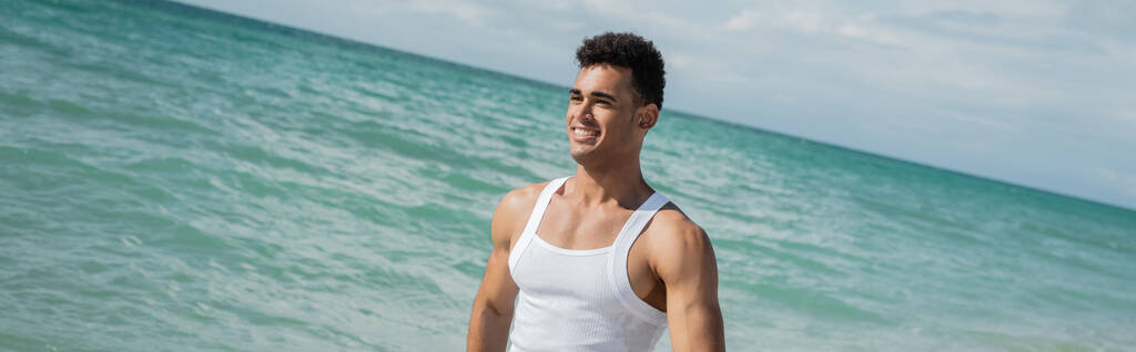 Muskularny kubański młodzieniec spacerujący po oceanicznej wodzie Miami South Beach, Floryda, sztandar - Zdjęcie, obraz