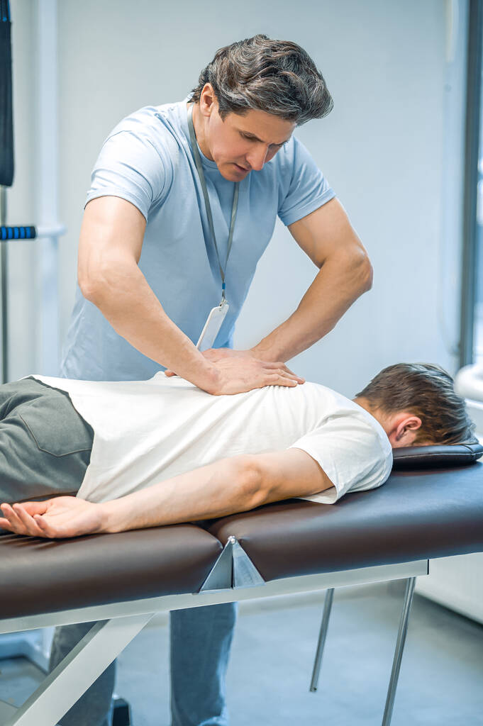 Masaje de espalda. Paciente masculino teniendo una sesión de rehabilitación masaje de espalda - Foto, imagen