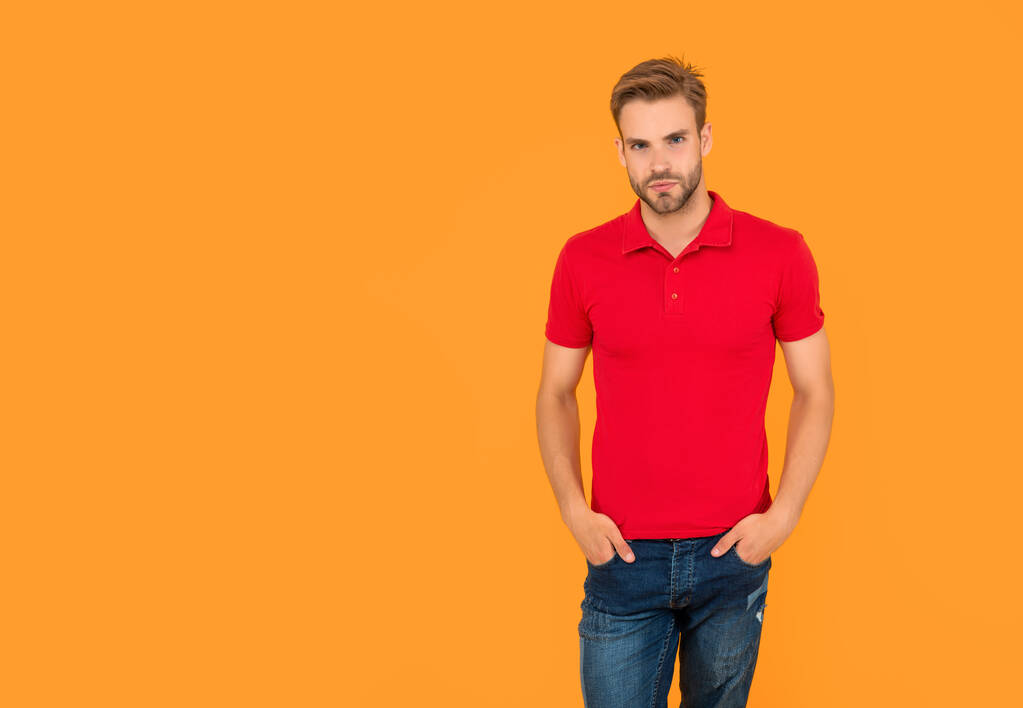 man with bristle in red shirt. young man with beard on yellow background with copy space. hair and beard care. confident and handsome unshaven guy. male casual fashion. mens beauty. - Photo, Image