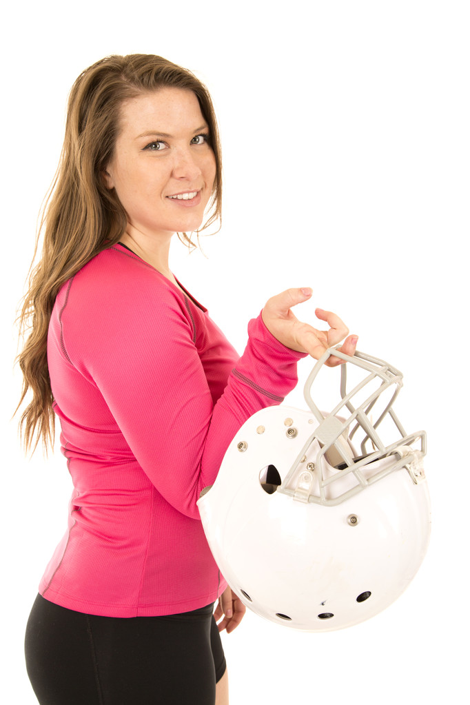 Modelo femenino vestido de rosa sosteniendo un casco de fútbol americano
 - Foto, imagen