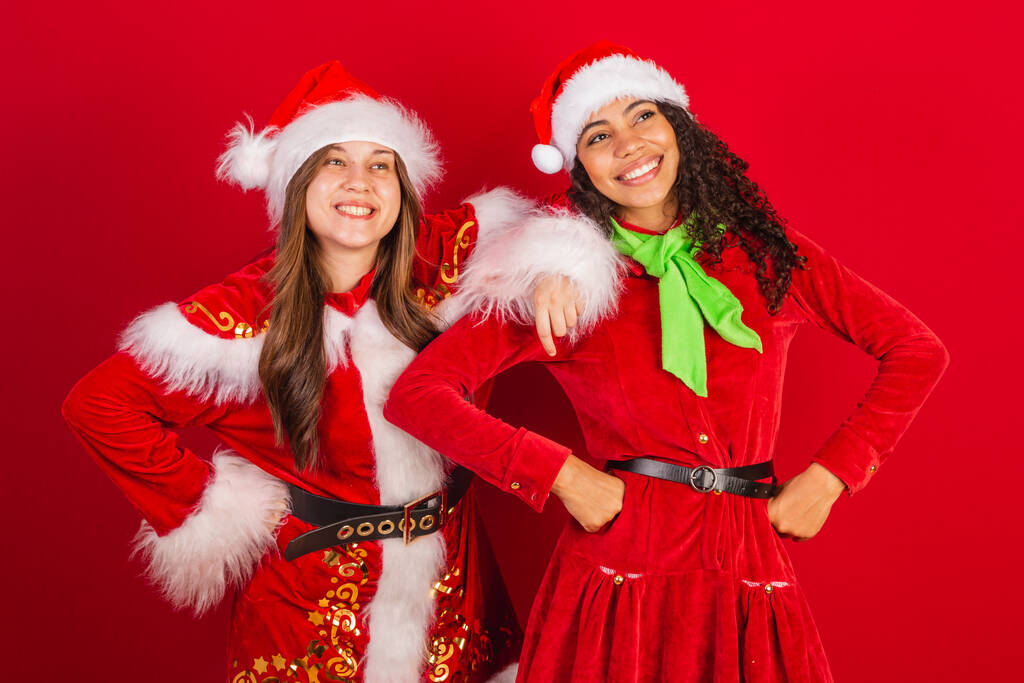 kaksi brasilialaista ystävää, pukeutunut jouluvaatteisiin, joulupukki. - Valokuva, kuva