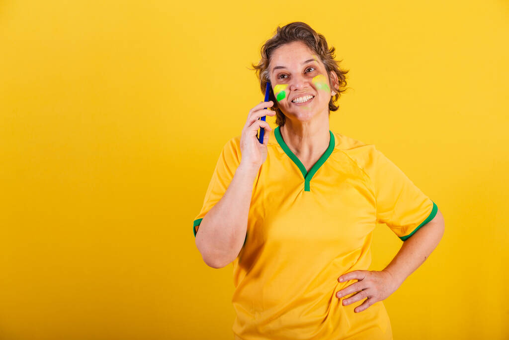 adulte femme adulte, fan de football brésilien, smartphone, appel vocal. - Photo, image