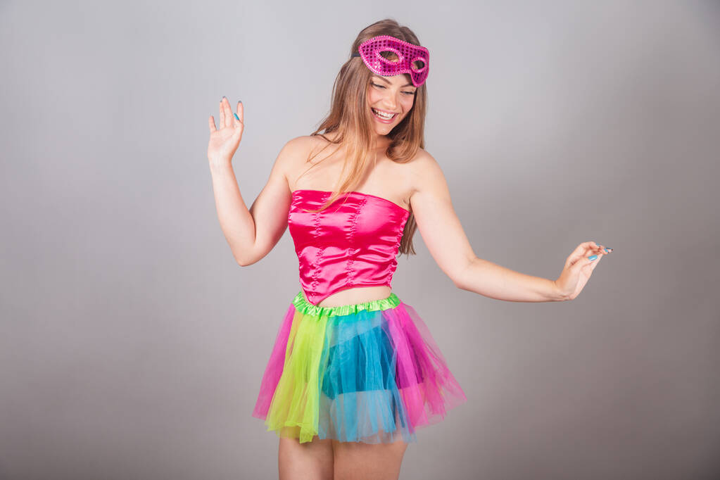 Brasilianische blonde Frau in rosa Karnevalskleidung. Mascara tragen, tanzen. - Foto, Bild