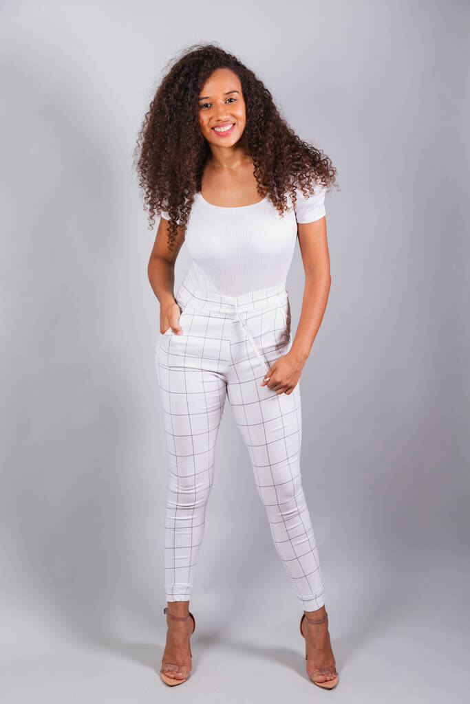 vertical photo, beautiful black Brazilian woman, dressed in white, casual clothes, smiling. - Photo, Image