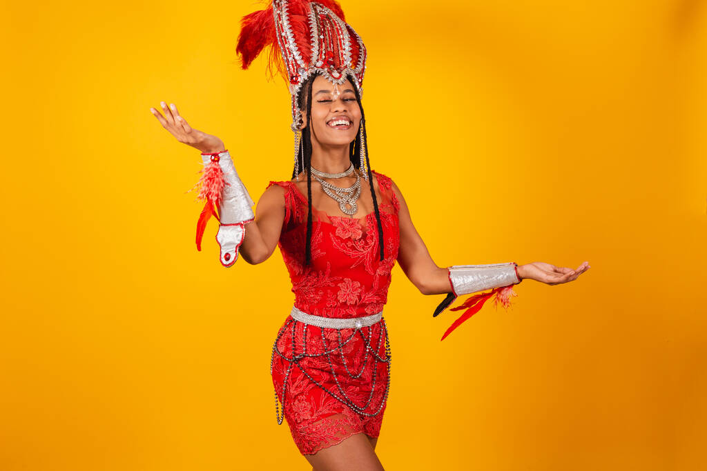 Beautiful black Brazilian woman, with red carnival clothes. With open arms, welcome. - Photo, Image