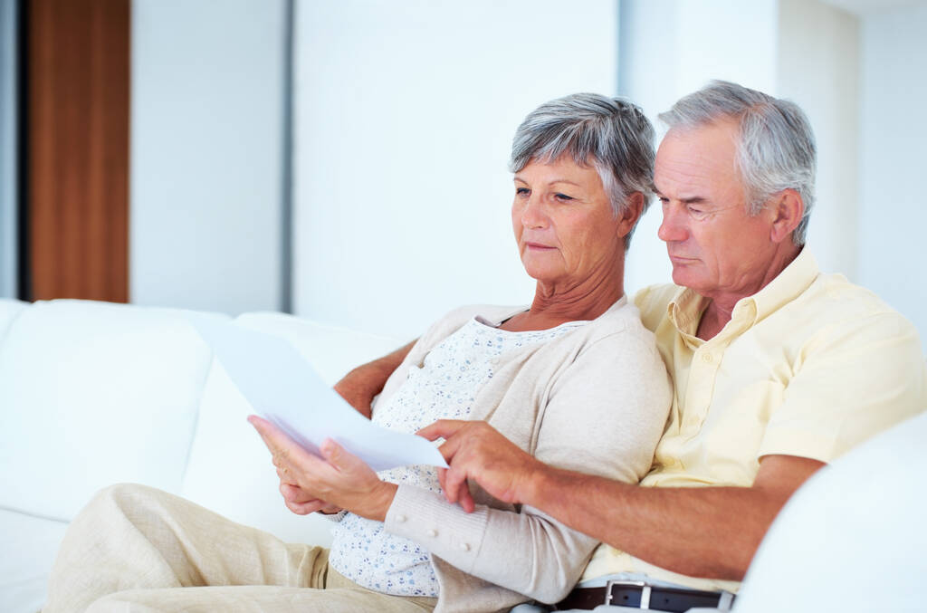 Home finance. Mature couple calculating bills while sitting on couch - Photo, Image