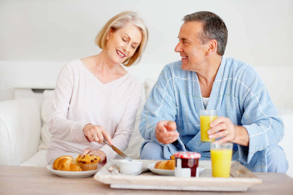 Boldog érett férfi és nő otthon reggeliznek. Portré egy boldog érett férfiról és nőről, akik otthon reggeliznek - Fotó, kép