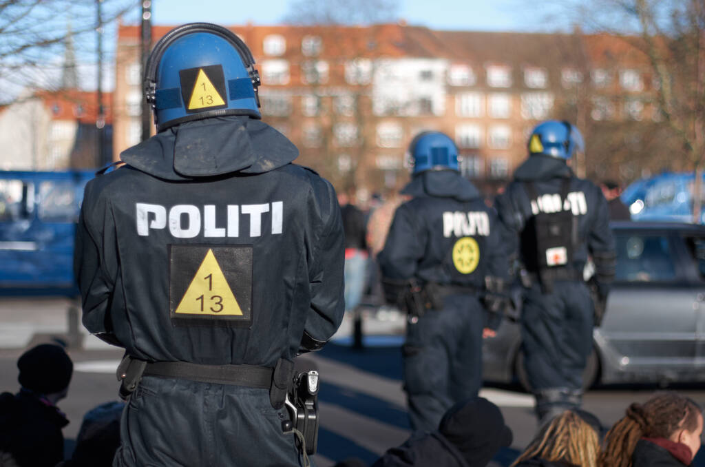 Sicherheit, Frieden und Personenkontrolle mit Polizeibeamten in der Stadt zur Durchsetzung, zum Schutz oder zur Sicherheit. Mutig, uniformiert und randalierend mit Menschen auf Dänemarks Straßen für Kundgebung, Menschenrechte oder Aktivisten. - Foto, Bild