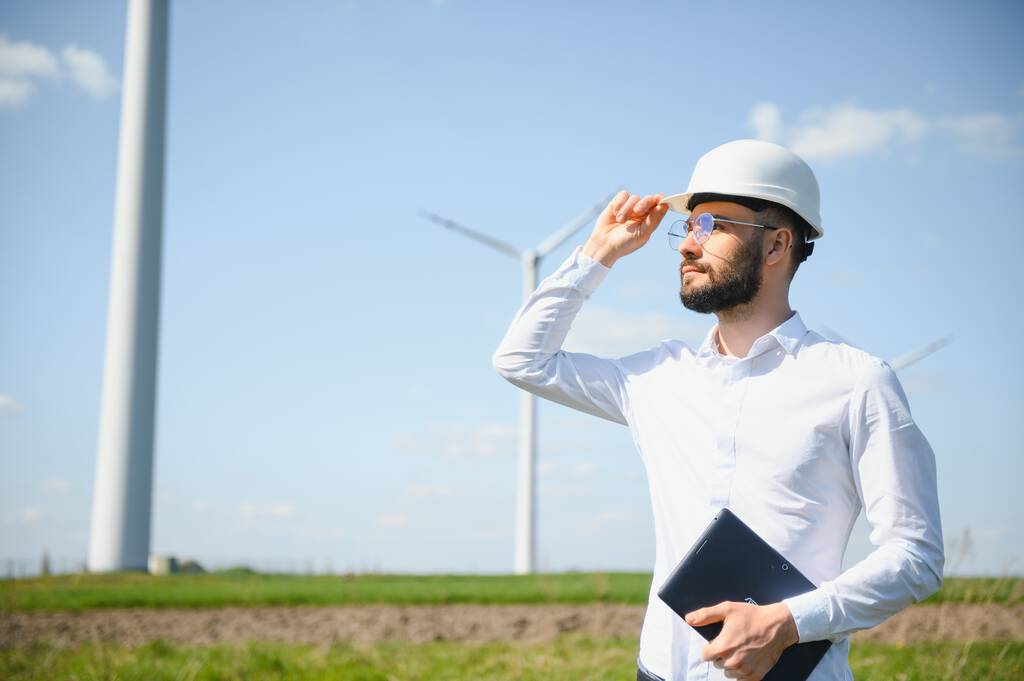 Inženýr kontroluje výrobu energie na větrných turbínách. Dělník v parku větrných mlýnů. - Fotografie, Obrázek