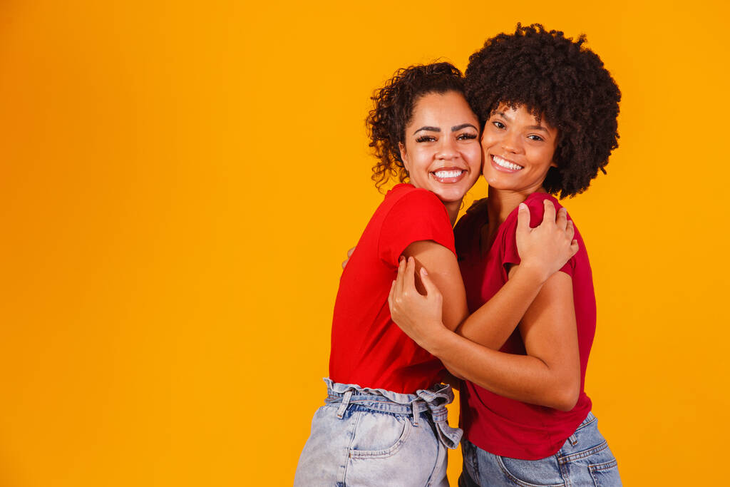 Afro lesbisches Paar auf gelbem Hintergrund. Homo-affektives Paar - Foto, Bild