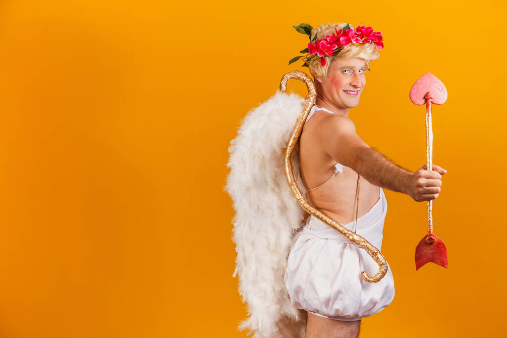 Concepto de San Valentín. Retrato del Dios del amor - Cupido con arco y flecha sobre fondo amarillo. - Foto, imagen