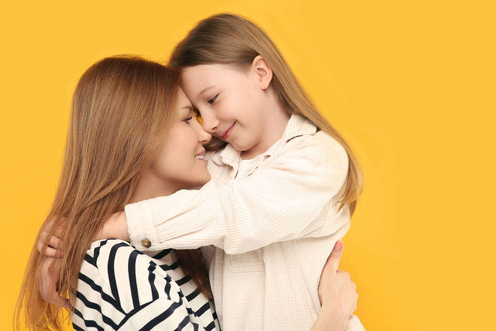 Muotokuva onnellinen äiti ja hänen söpö tytär oranssi tausta - Valokuva, kuva