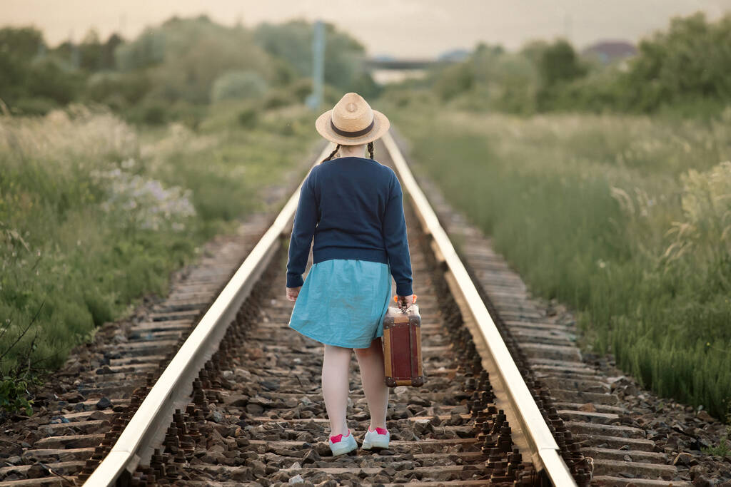 Foto de estilo retro de niña con equipaje viejo en los ferrocarriles - Foto, imagen