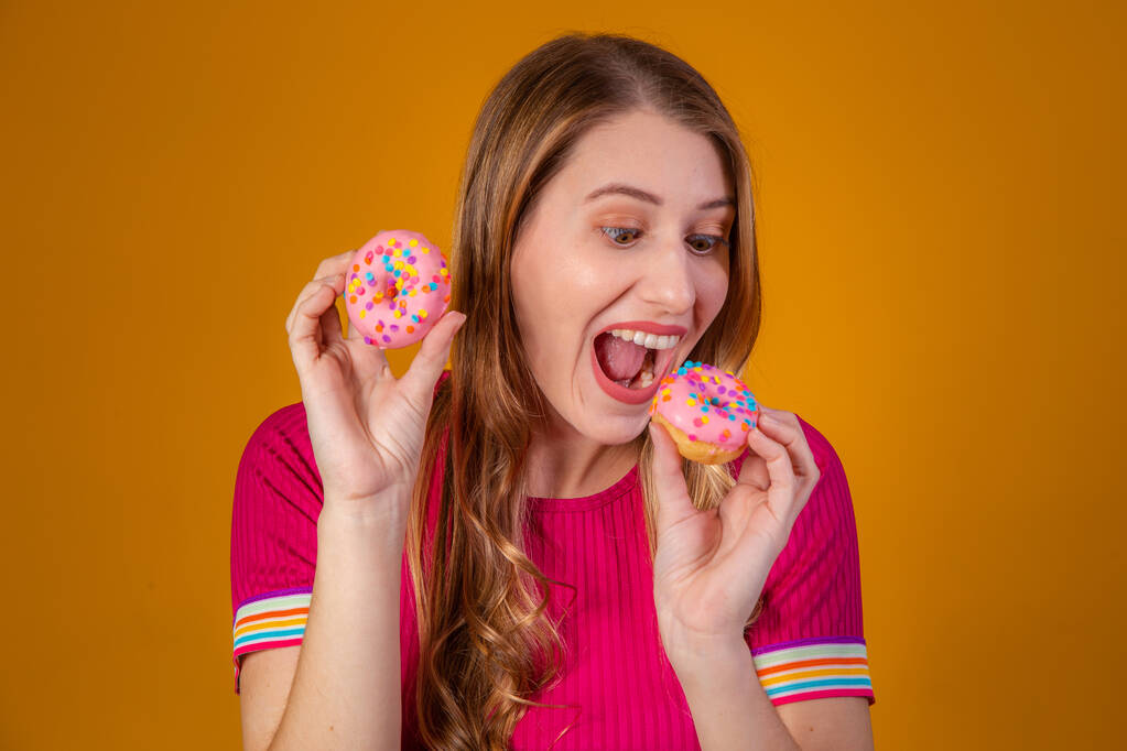jovem loira com donuts no fundo amarelo. - Foto, Imagem