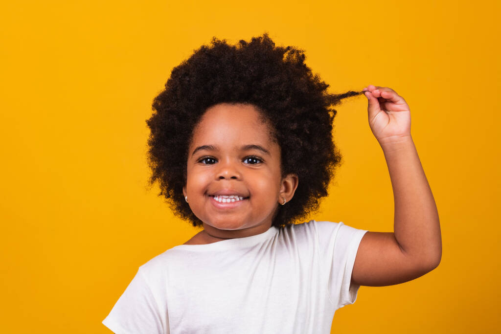 χαριτωμένο afro κορίτσι με μαύρα μαλλιά δύναμη χαμογελώντας στην κάμερα. Μαύρη Μέρα. Ημέρα των παιδιών - Φωτογραφία, εικόνα