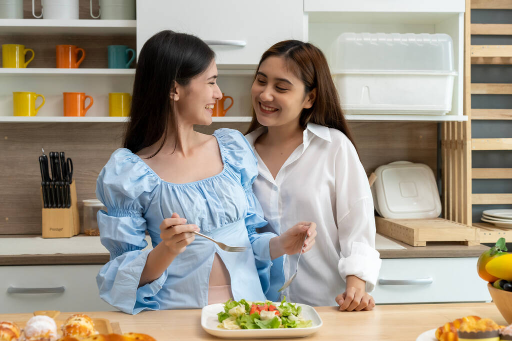Азійська молода красива жінка і її дівчина їдять з щастям разом на кухні, момент романтичного часу коханки, ЛГБТ концепції свободи любові, копіюйте простір. - Фото, зображення