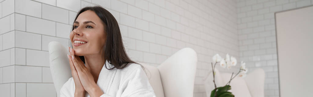 Nainen valkoisessa kylpytakissa lääketieteellisen toimenpiteen aikana kauneusklinikalla. Laadukas kuva - Valokuva, kuva