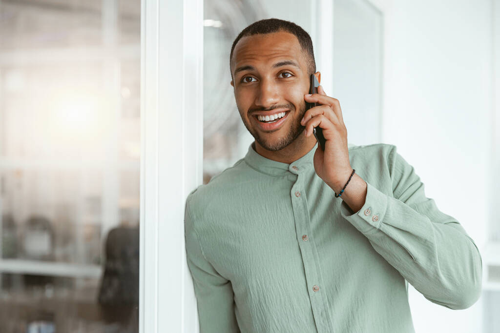 Empresário africano sorrindo falando telefone com o cliente enquanto estava no escritório. Fundo desfocado - Foto, Imagem