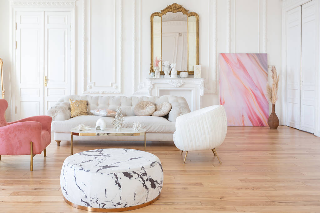 bardzo lekki barokowy styl luksusowe wnętrze dużego salonu. Białe ściany ozdobione niesamowitą sztukaterią. Apartament w stylu królewskim z eleganckimi meblami z elementami złota - Zdjęcie, obraz