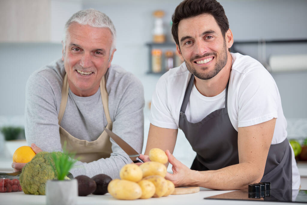 Csípő fia, az idősebb apja, főzés a konyhában - Fotó, kép