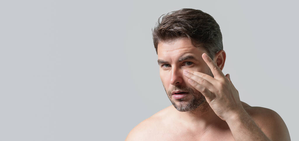 Kaukasische Schönheit Mann verwenden feuchtigkeitsspendende Gesichtsbalsam für gesunde Haut, männliche Hautpflege-Konzept. Männliche Schönheitspflege Porträt. Gesundes, sauberes Gesicht nach der Rasur, Gesichtsbehandlung, Plakat, Kopierraum - Foto, Bild