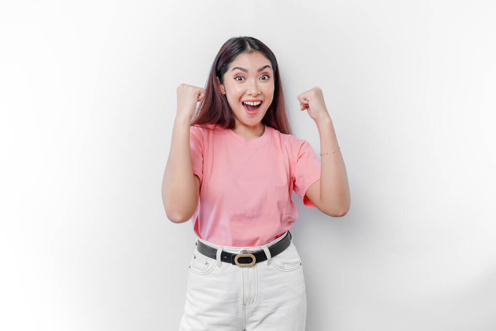Een jonge Aziatische vrouw met een gelukkige succesvolle uitdrukking dragen roze t-shirt geïsoleerd door witte achtergrond - Foto, afbeelding