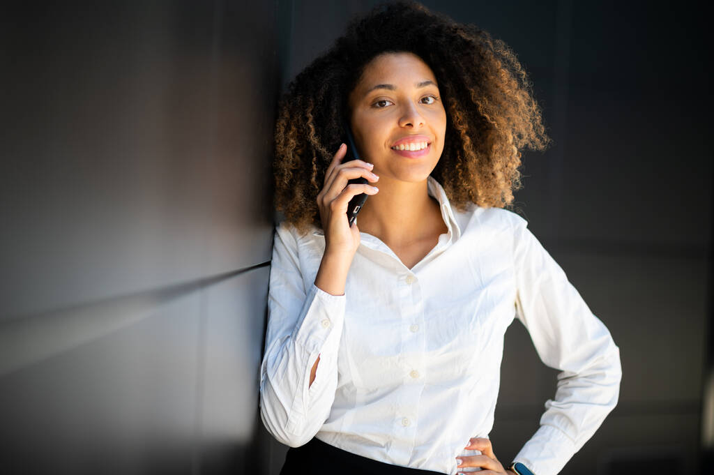 Πορτρέτο μιας νεαρής Αφρο-Αμερικανίδας που μιλάει στο τηλέφωνο - Φωτογραφία, εικόνα