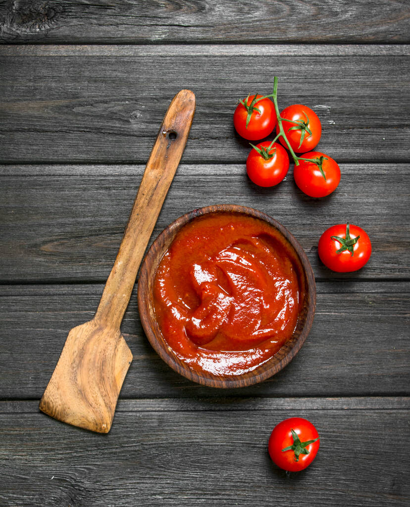 Kepçe ve kiraz ile ahşap kase domates sosu. Ahşap arka planda - Fotoğraf, Görsel
