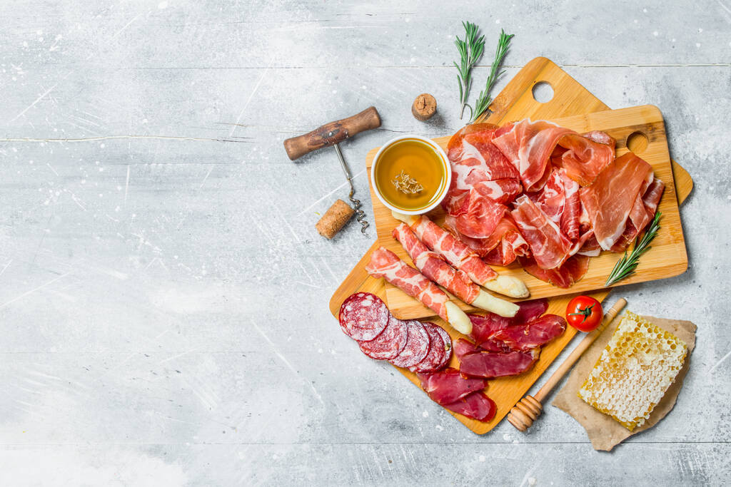 Antipasto background.The various meats. On a rustic background. - Photo, Image